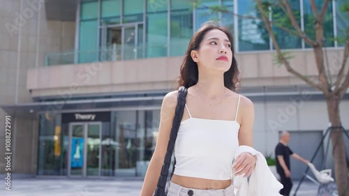 Charming young asian businesswoman walking in the urban city slow motion