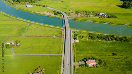 Aerial drone view of green paddy crops with waterway canal at Kampung Wai, Perlis, Malaysia photo