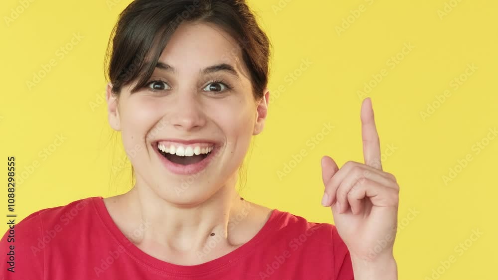 Joyful expression. Pointing finger. Excited happy delighted woman indicating towards free space isolated on yellow background. Joyful expression. Pointing finger. Excited happy delighted woman indicating towards free space isolated on yellow background.