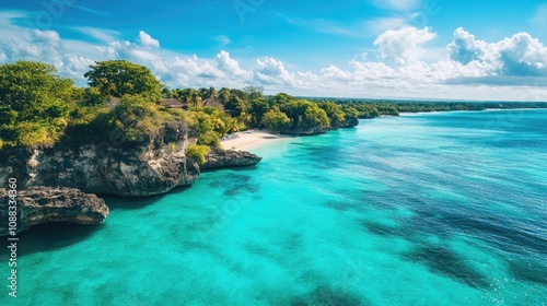 Aerial view of a tranquil shoreline with vibrant turquoise waters, lush green cliffs, and a sandy beach under a bright blue sky with fluffy clouds.