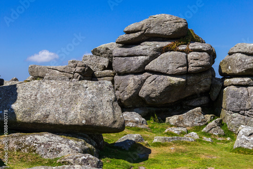 Tor or standing rocks on Dartmoor, Devon UK. Bright blue sky with strong sunlight and light clouds