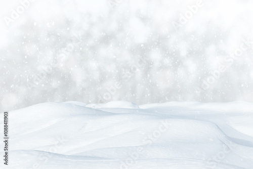 Fresh clean snow falls against the background of a forest and a snowdrift. Winter colorful landscape. Heavy snowfall concept.
