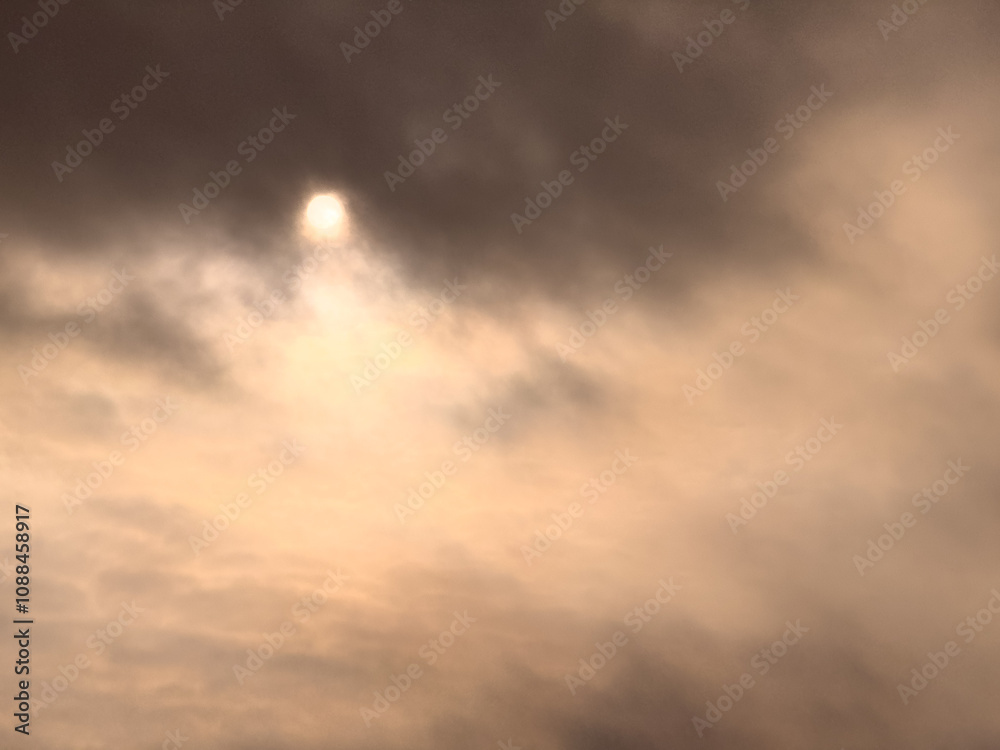 A cloudy sky with a sun shining through it A cloudy sky with a sun shining through it