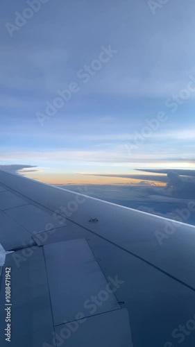 4k real time footage of airplane flight looking out from plane window. Vertical footage view from the window 
with silver wing of the airplane.