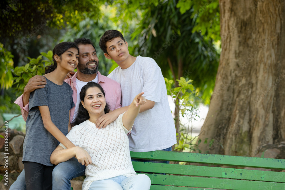 Portrait of happy Indian Family looking towards the empty spaces and pointing Portrait of happy Indian Family looking towards the empty spaces and pointing