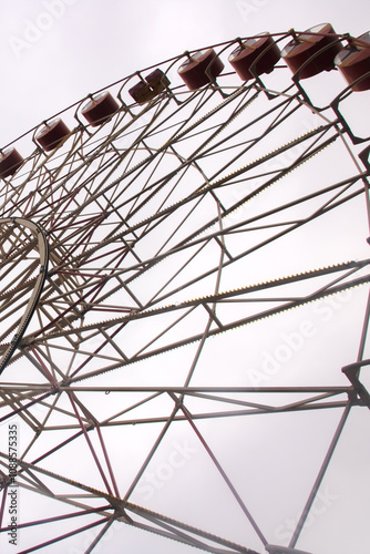 Gazing up at a towering ferris wheel set against a cloudy sky above photo