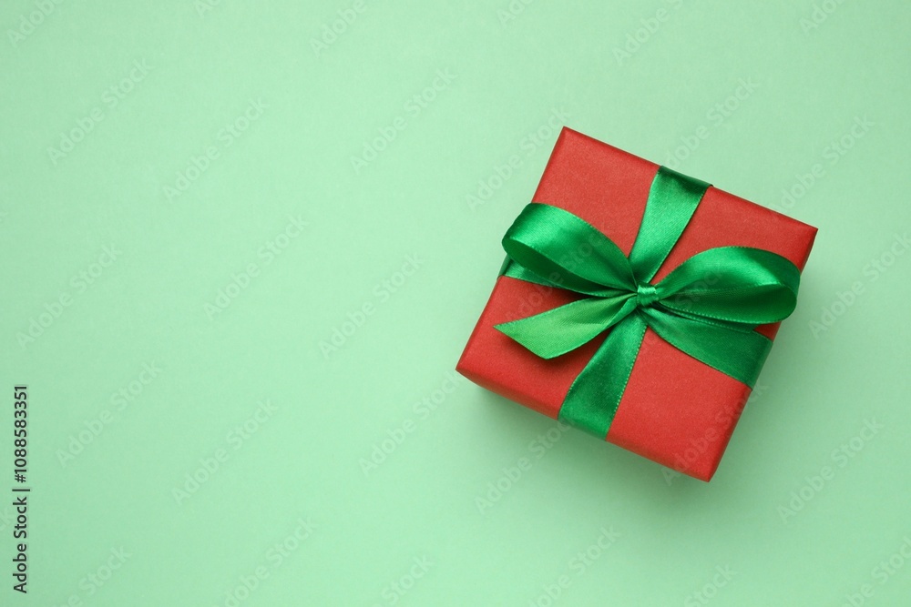 Beautiful gift box tied with bow on color background Beautiful gift box tied with bow on color background