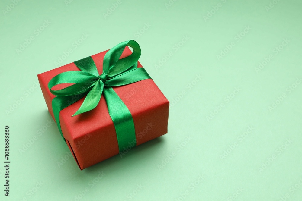 Beautiful gift box tied with bow on color background Beautiful gift box tied with bow on color background