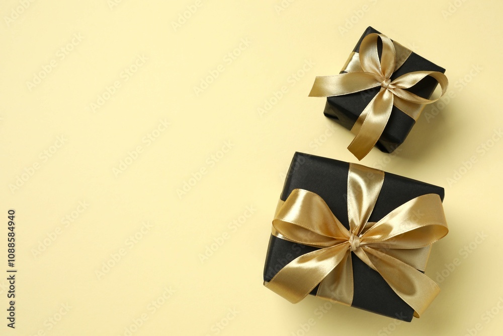 Beautiful gift boxes tied with golden bows on color background Beautiful gift boxes tied with golden bows on color background