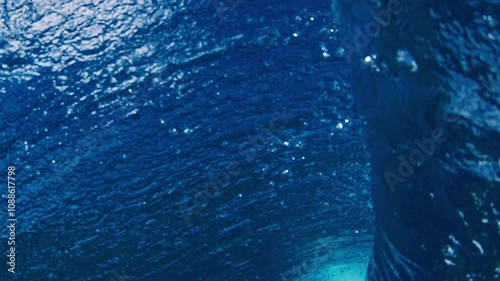 Ocean wave breaks. Underwater view of a surfing spot in the Maldives