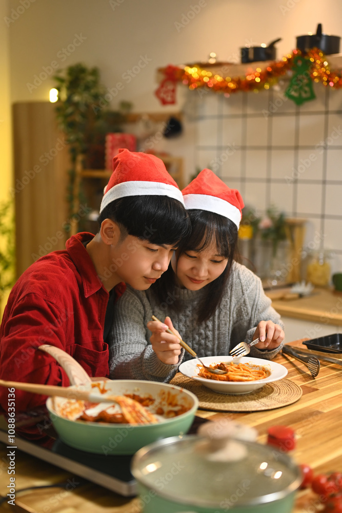 Happy young couple tasting a delicious homemade pasta dish in a kitchen Happy young couple tasting a delicious homemade pasta dish in a kitchen