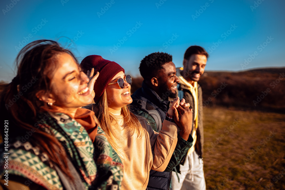 Smiling group of friends having fun while hiking together on hill at sunset. Smiling group of friends having fun while hiking together on hill at sunset.