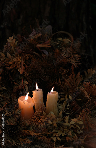 burning candles in dry autumn leaves, abstract dark nature background. mysterious fairy scene. Samhain, Halloween holidays. Witchcraft, esoteric spiritual ceremony, magic ritual with wax candles photo