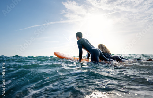 Foto Fit couple surfing at sunset