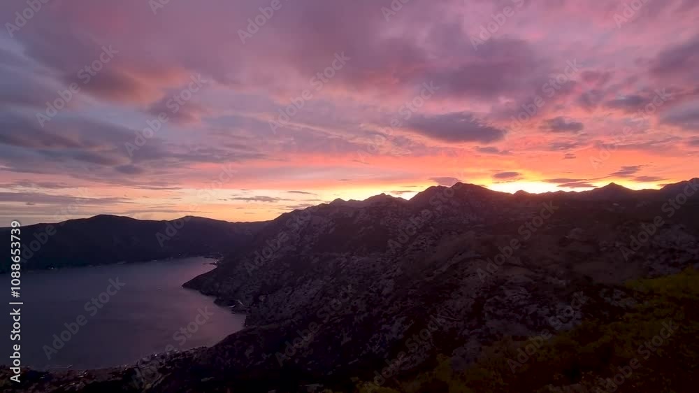 Experience the magic of a stunning sunset as vibrant colors paint the sky above rugged mountains. The peaceful ocean reflects the beauty of nature, creating a serene atmosphere at Kotor Bay Experience the magic of a stunning sunset as vibrant colors paint the sky above rugged mountains. The peaceful ocean reflects the beauty of nature, creating a serene atmosphere at Kotor Bay