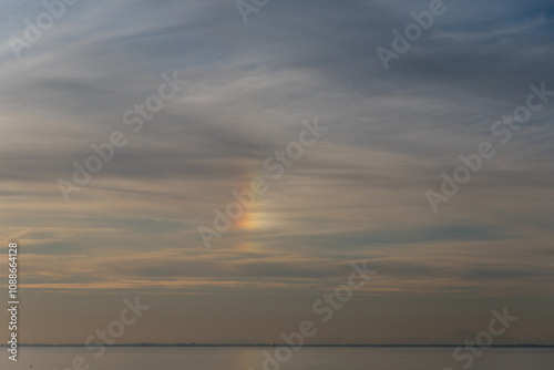 Lo spettacolo meraviglioso delle nuvole iridescenti sopra il mare davanti all’isola di Pellestrina poco prima del tramonto photo