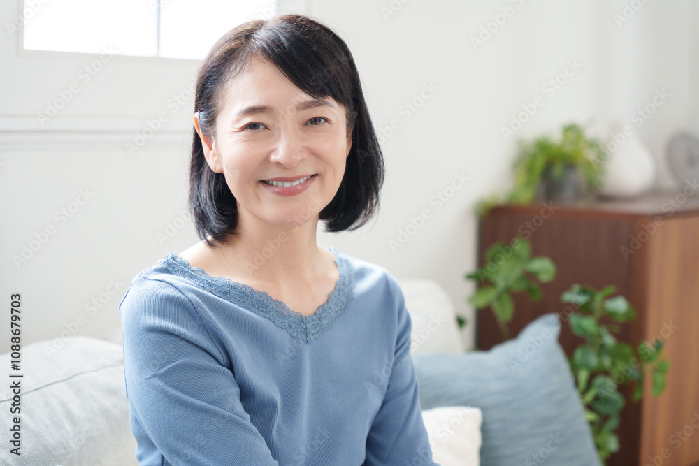 ソファに座る笑顔のミドル女性