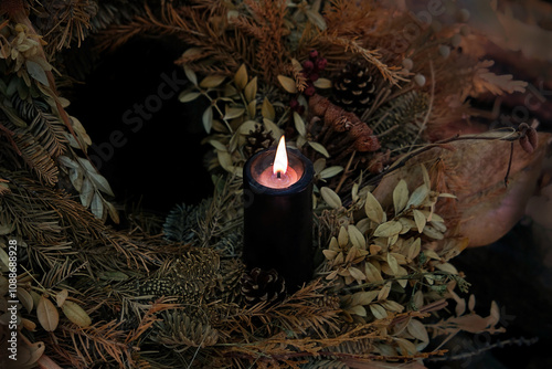 burning black candle in autumnal leaves, abstract dark nature background. mysterious fairy scene. Samhain, Halloween holidays concept. Witchcraft, esoteric spiritual ceremony. magic ritual photo