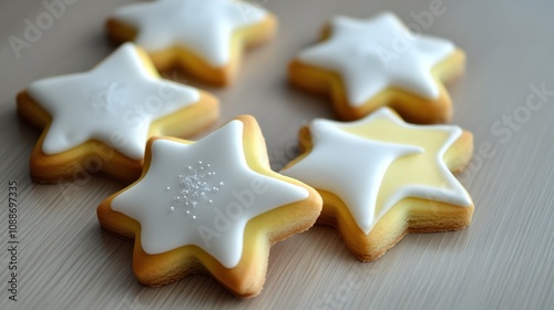 Four white and yellow star shaped cookies with white icing