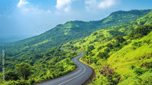 Serene Scenic Landscape with Winding Road Through Lush Green Hills Under a Bright Blue Sky Capturing the Tranquility of Nature and Scenic Beauty