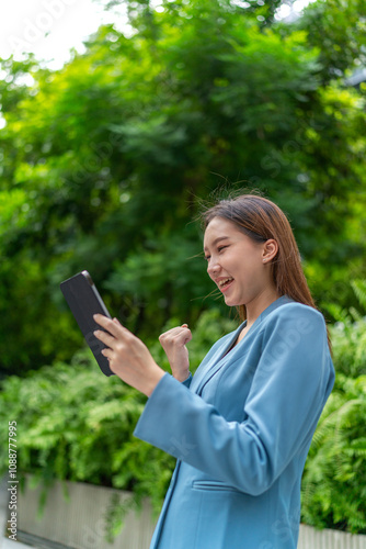 Asian Businesswoman Using Digital Tablet Amid Greenery in A Park