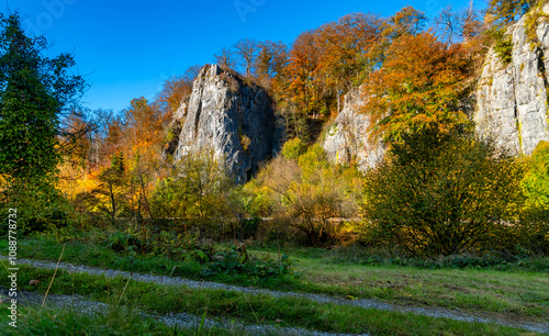 The “Sieben Jungfrauen” (Seven virgins) are a well-known limestone rock formation in the idyllic Hönne Valley in the Sauerland (Germany). Panorama view on sunny a autumn ay with colorful tree foliage. photo