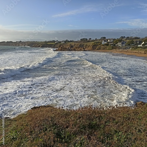 big waves in the beach in clohars carnoet, france. Scenic coastline in Finestere, Brittany, with sea foam of strong tides in Atlantic ocean.  photo