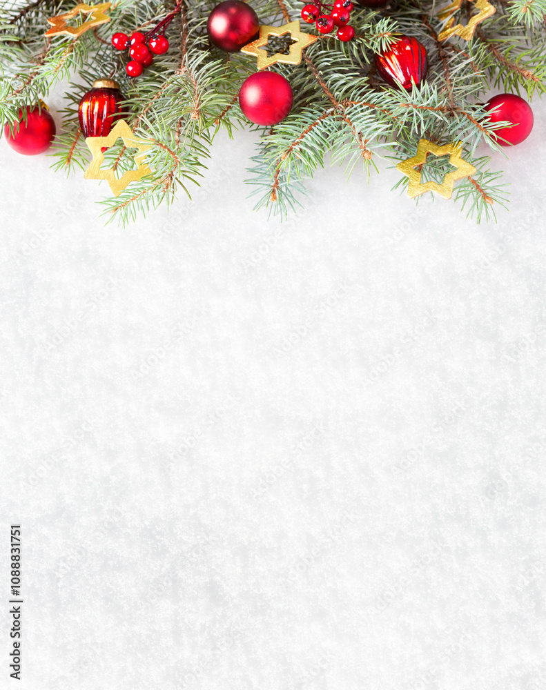 Fir branches with Christmas ornaments on the background of natural snow with empty space for text.