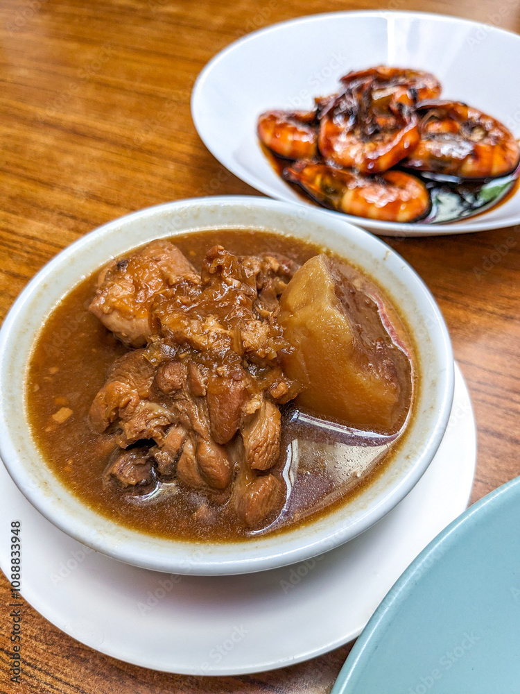 Top view of a round white plate of nyonya dish ayam pongteh and assam prawn Top view of a round white plate of nyonya dish ayam pongteh and assam prawn