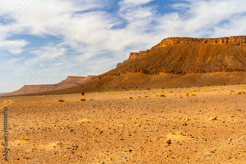 Dry stone desert and lonely table mountain in the background. Morocco

