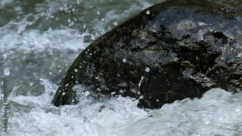 The splash of fast river water over the rocks. The fast flow of river water. The water looks clean and fresh. The surface of the river water. Natural light, real time The splash of fast river water over the rocks. The fast flow of river water. The water looks clean and fresh. The surface of the river water. Natural light, real time