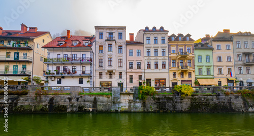 photography of colourfull buildings in front of the river Ljubljanica in Ljubljana, Slovenia at day during a foggy morning