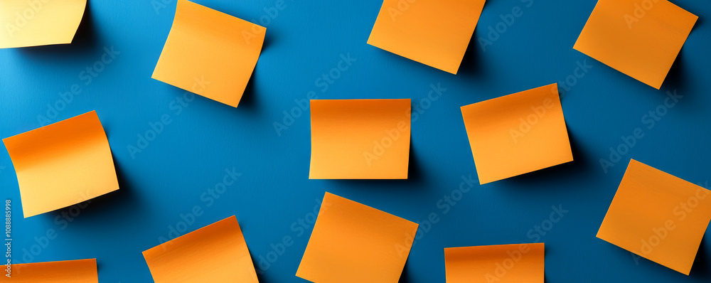New year plan 2025 and resolutions concept. A flat lay of vibrant orange sticky notes scattered on a blue background, creating a visually striking contrast. New year plan 2025 and resolutions concept. A flat lay of vibrant orange sticky notes scattered on a blue background, creating a visually striking contrast.