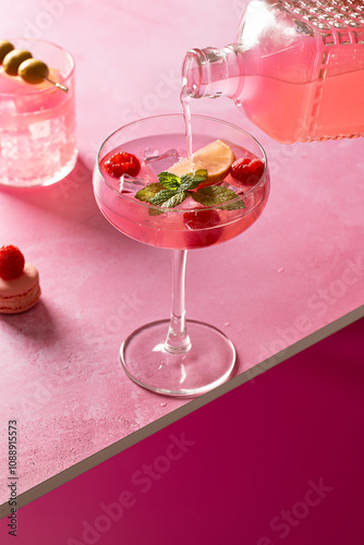 Elegant pink gin cocktail with lemon and mint garnish