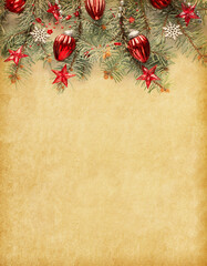 Vintage Christmas and New Year holidays background. Fir branch with Christmas decorations on old yellowed paper background  with empty space for text.  Flat lay.  ..