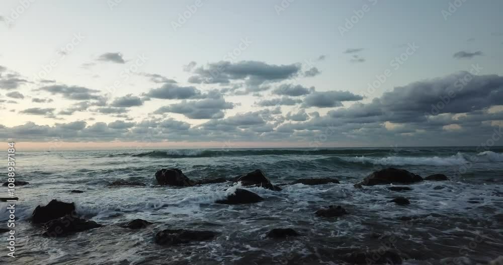 Aerial view, drone flight over beautiful beach with waves crashing on the beach in Sicily, Italy