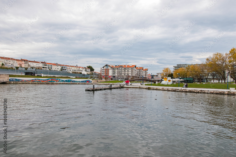Obraz premium Paisagem serena vista do Cais da Fonte Nova, Aveiro, com seus canais tranquilos, barcos coloridos e arquitetura típica, refletindo a beleza única e o charme pitoresco da cidade portuguesa