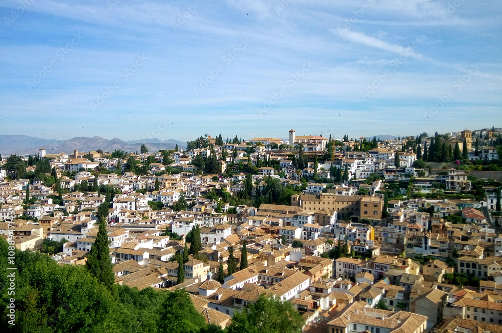 Fototapeta premium A panoramic view of a charming Spanish town nestled amidst rolling hills. A picturesque cityscape of Albaicin traditional Spanish town. A stunning aerial view of a historic Spanish Granada city