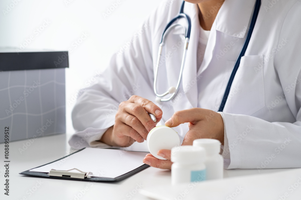 Doctor's hands hold the composition on a jar of pills, the concept of nutrition, a healthy lifestyle, the selection of a vitamin complex Doctor's hands hold the composition on a jar of pills, the concept of nutrition, a healthy lifestyle, the selection of a vitamin complex