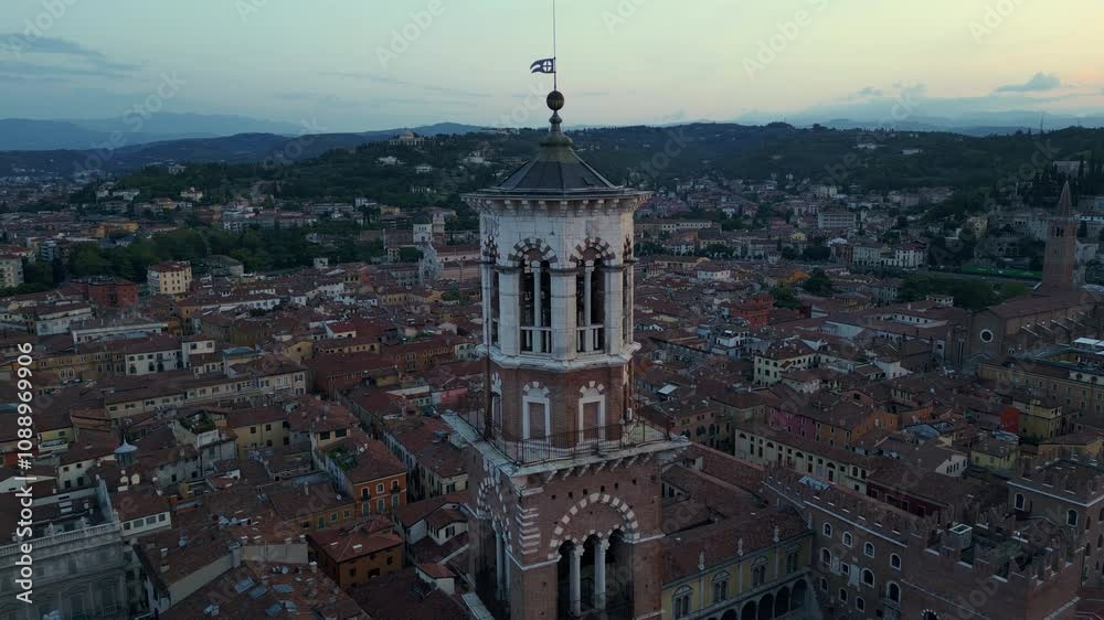Torre dei Lamberti towers over Verona's terracotta rooftops and hills, capturing the city's rich history and culture. Drone shot Torre dei Lamberti towers over Verona's terracotta rooftops and hills, capturing the city's rich history and culture. Drone shot