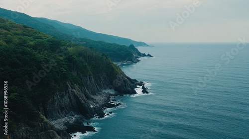 Serene Coastal Landscape with Rugged Cliffs and Calm Ocean Waves Under a Cloudy Sky in a Remote Natural Setting