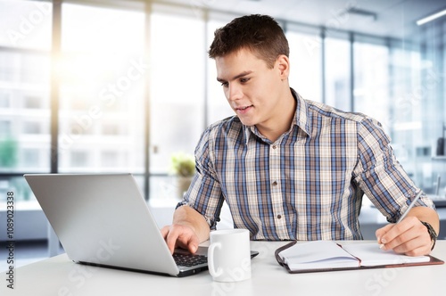 Confident young male professional working in modern office.