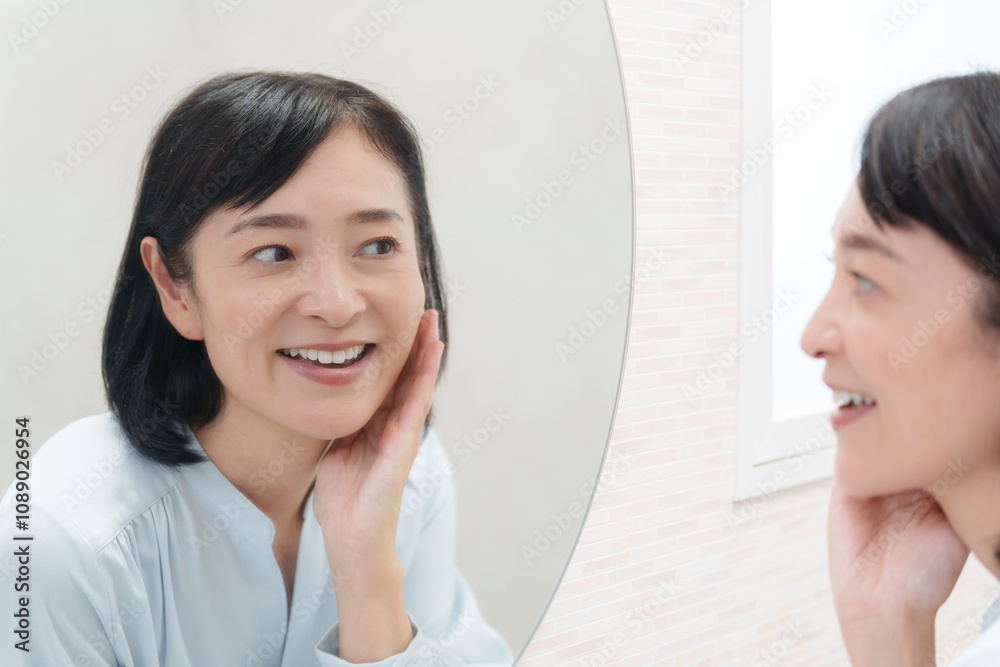 鏡を見てスキンケアするミドル女性（美容）..