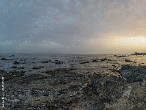 Rocky Beach in Málaga at Sunset with Calm Waves and Soft Sky