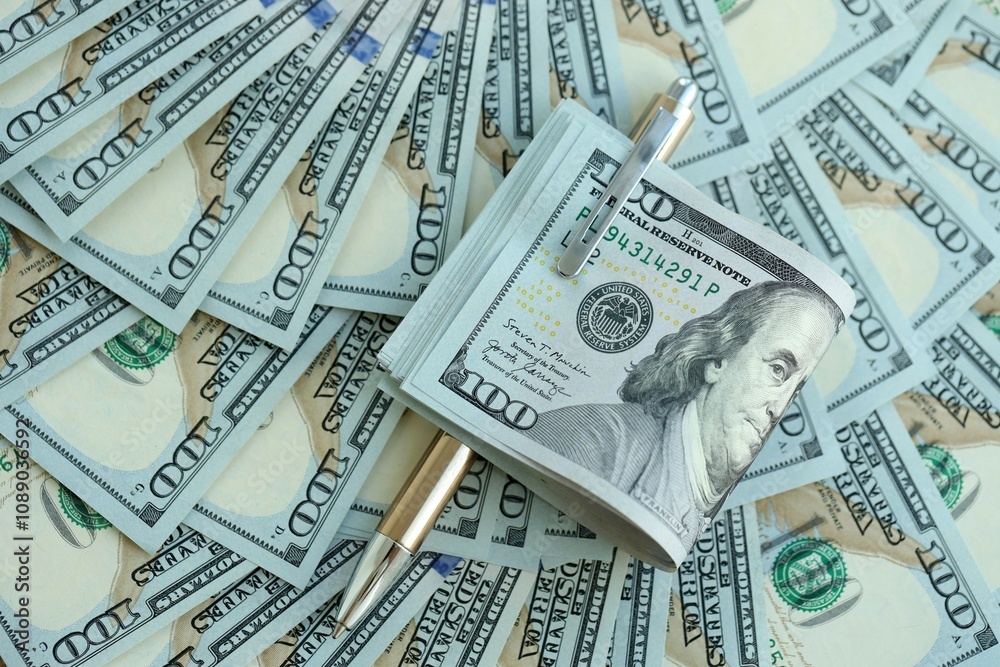 Golden pen clipping big amount of hundred dollar bills US banknotes Golden pen clipping big amount of hundred dollar bills US banknotes