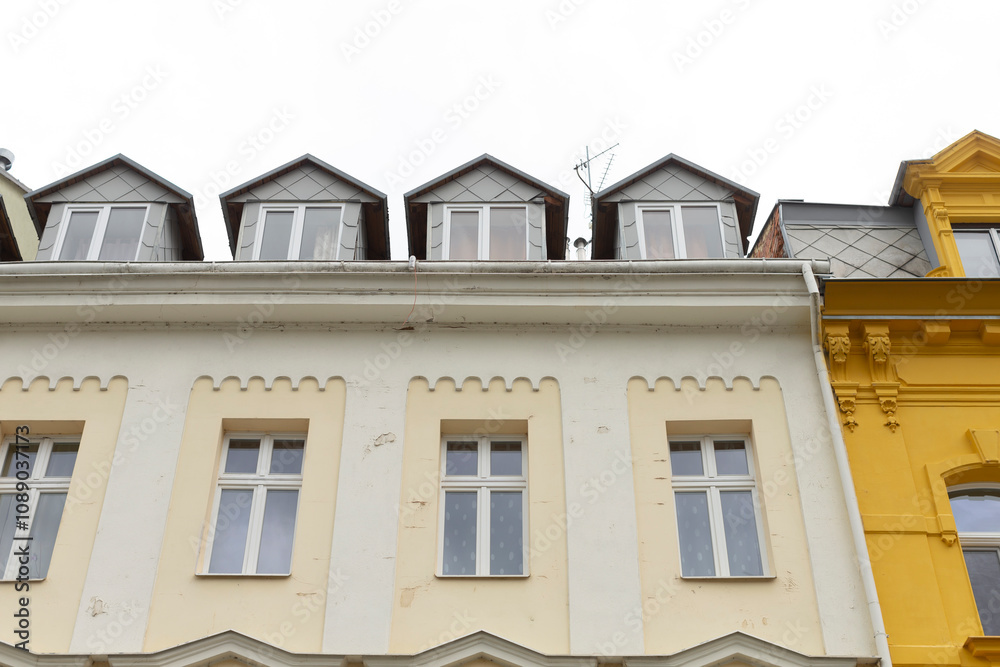 This impressive building has a beautifully designed facade with charming dormer windows and vibrant colors, showcasing its architectural elegance and unique style that stands out in the neighborhood This impressive building has a beautifully designed facade with charming dormer windows and vibrant colors, showcasing its architectural elegance and unique style that stands out in the neighborhood