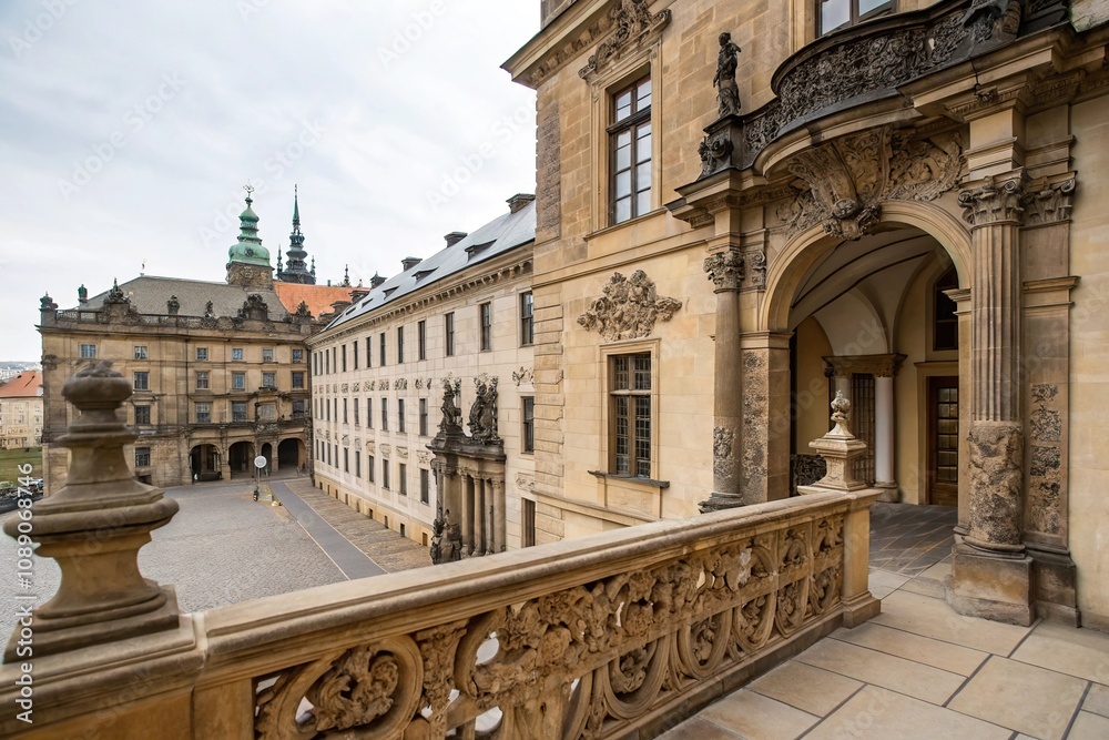 Naklejka premium Ancient stone balcony overlooking the main entrance of a historic building in Prague, adorned with intricate carvings and ornate details, prague, mystique, entrance, ornate