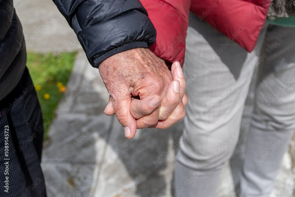 Elderly Hands Intertwined While Walking