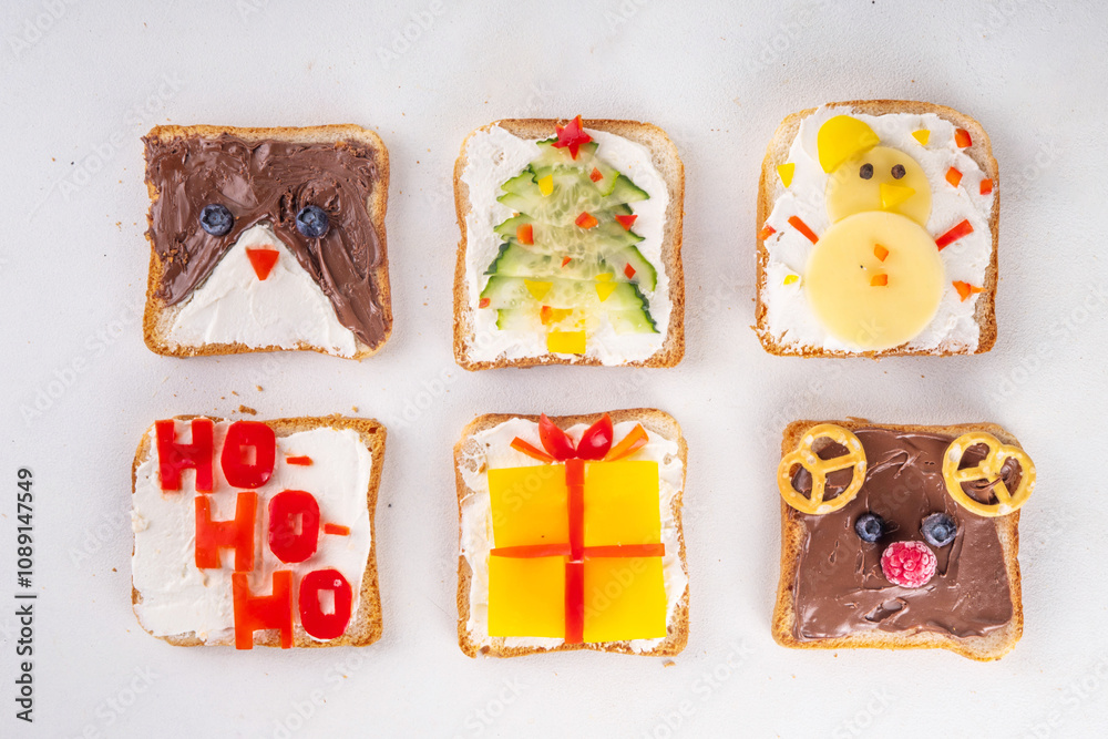 Obraz premium Christmas funny creative toasts sandwich for kids breakfast. Homemade Christmas morning sandwiches in form of gift, Christmas tree, deer, snowman, penguin, with cheese, fruit, chocolate, vegetables