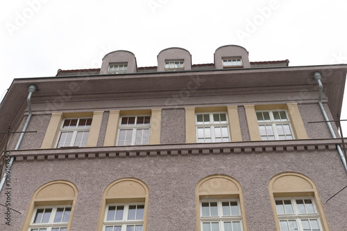 This stunning view showcases a beautifully designed upperfloor facade with elegant arched windows and decorative elements that enhance its architectural beauty, making it a remarkable sight photo